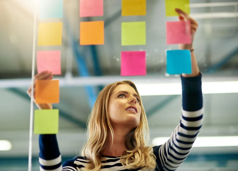 Women using productivity technique of a post it board